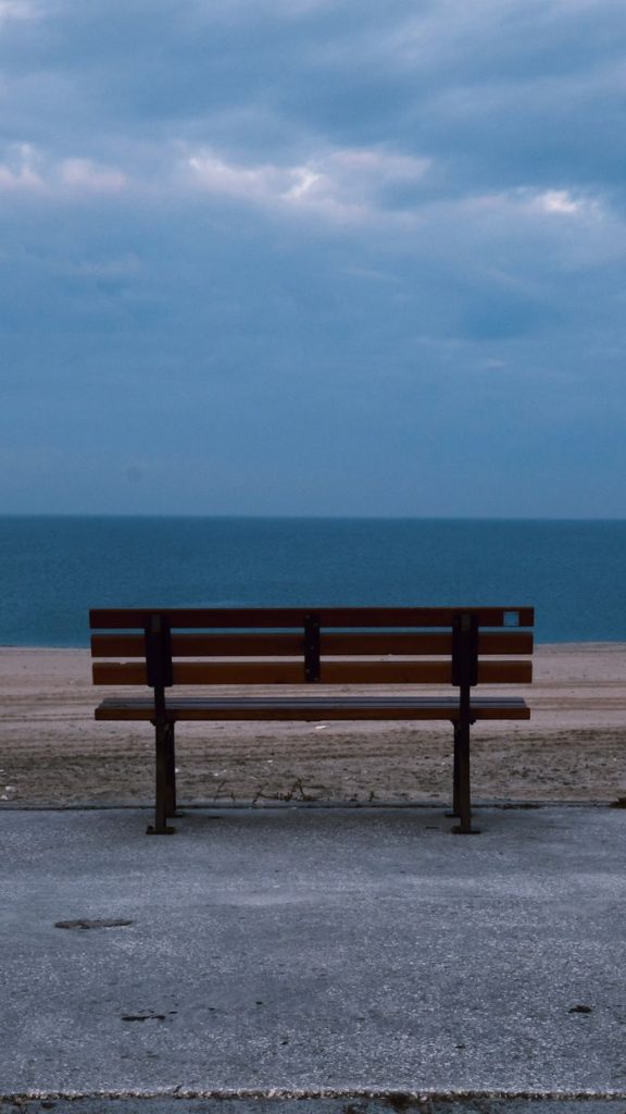 Banc vide devant l'océan, symbole du temps non productif et de la flânerie stratégique